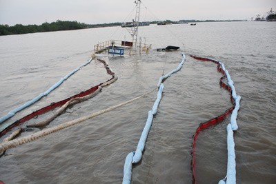 Old absorbent floats are dropped on the river water to prevent an oil spill Old absorbent floats are dropped on the river water to prevent an oil spill
